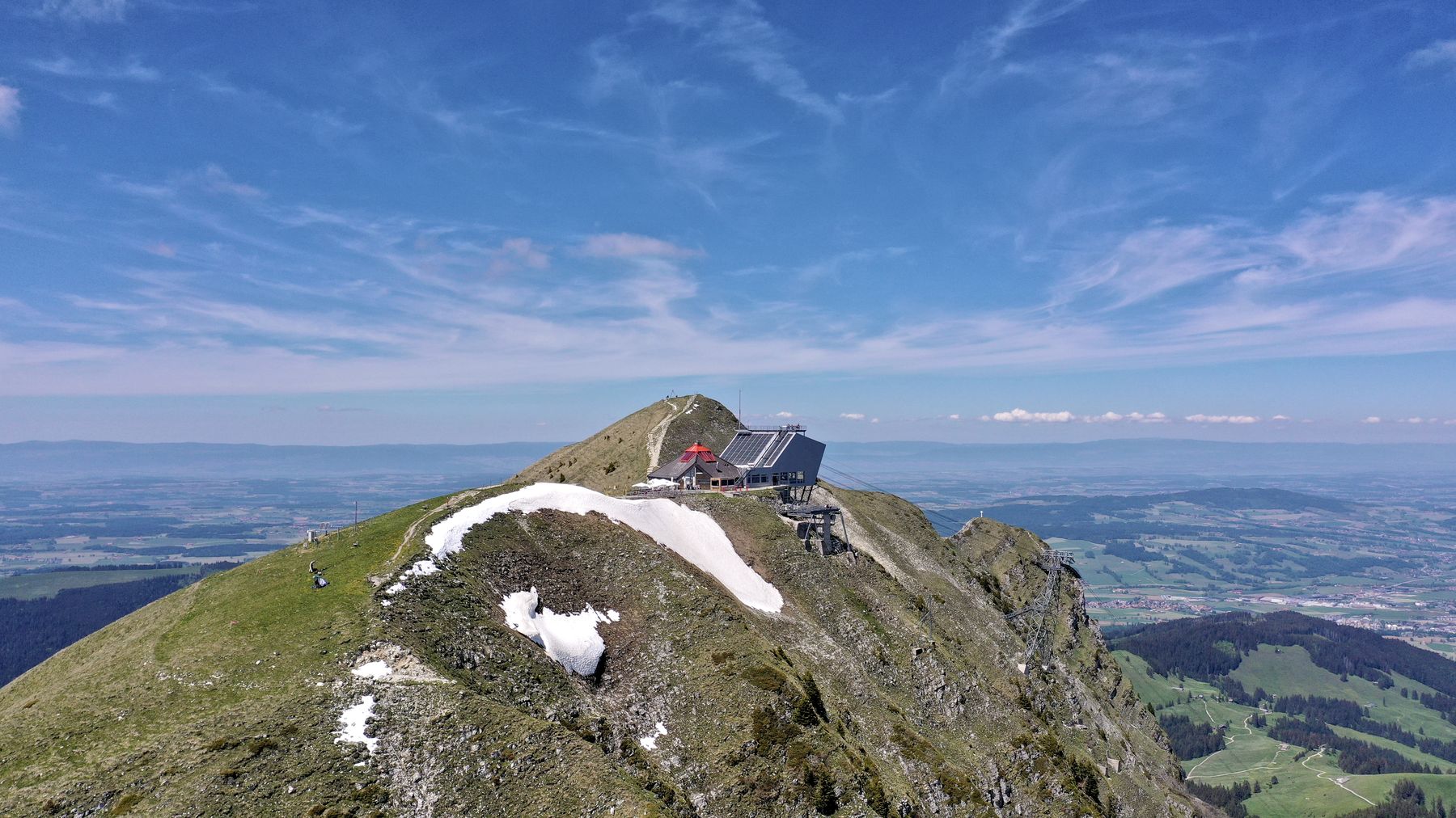 Summit of Le Moléson with the station and a patch of late snow