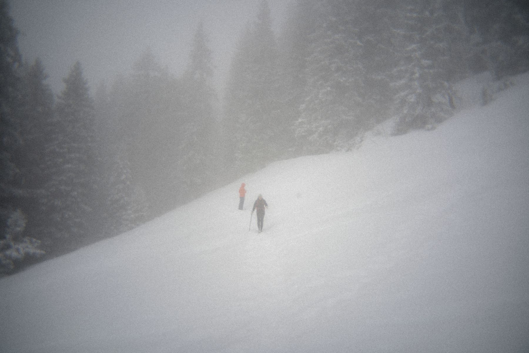 Two people on a foggy snow slope at Le Folly