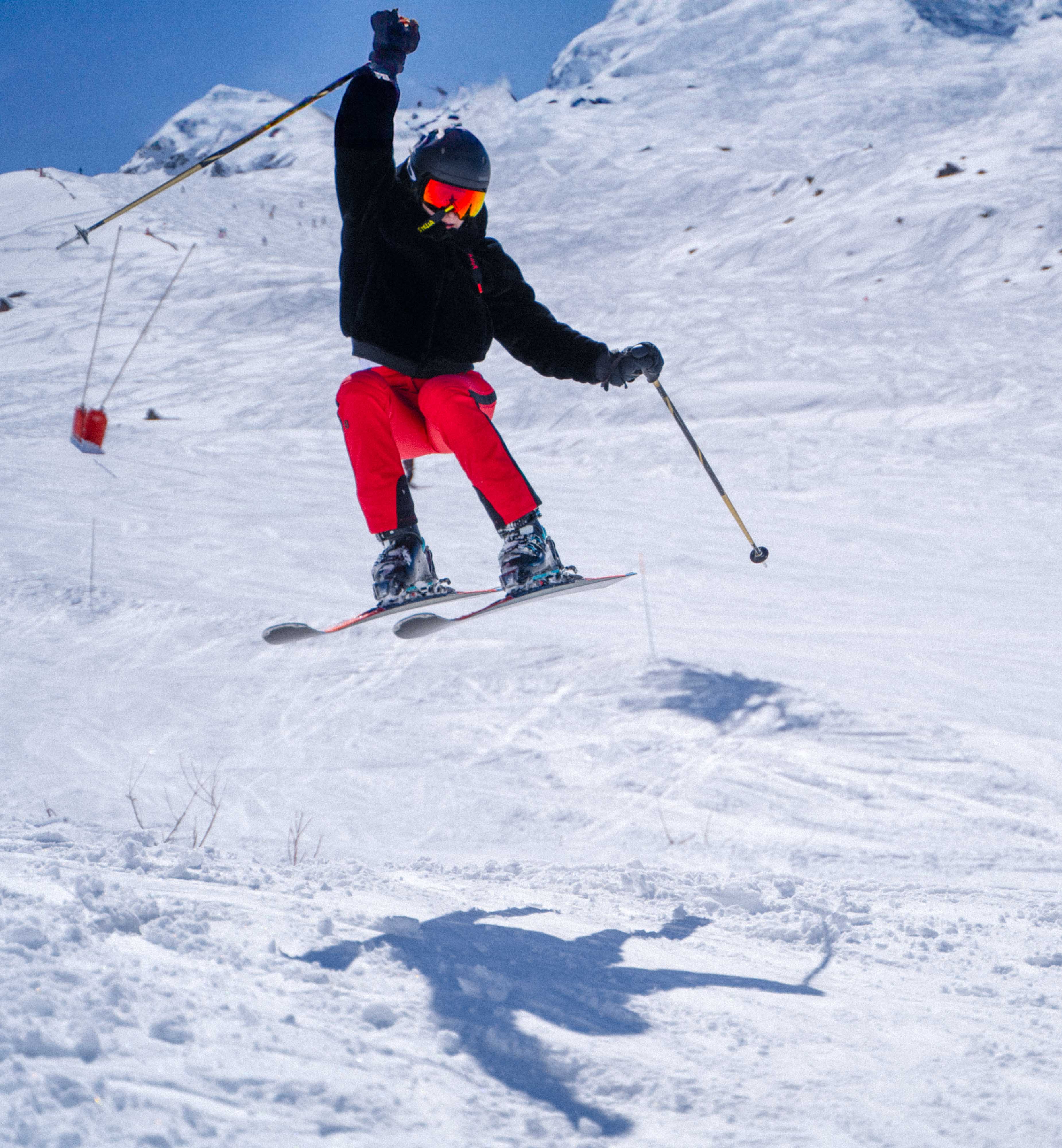 Skier jumping on a sunlit alpine slope