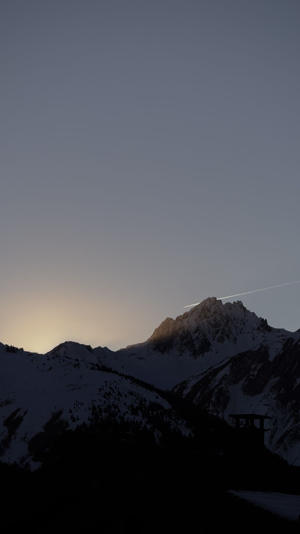 Dusk silhouette of a peak above Les Belleville